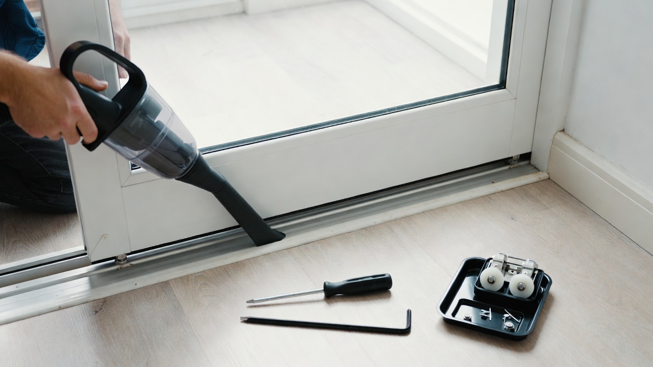 How to clean sliding glass door tracks - vacuuming the bottom rail with small tools